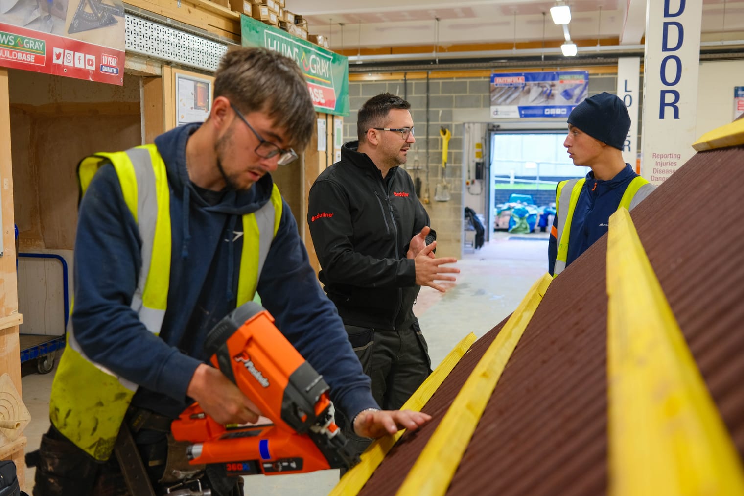 Roofing apprentice using a nail gun on a practice roof during the CPD session at Derwentside College