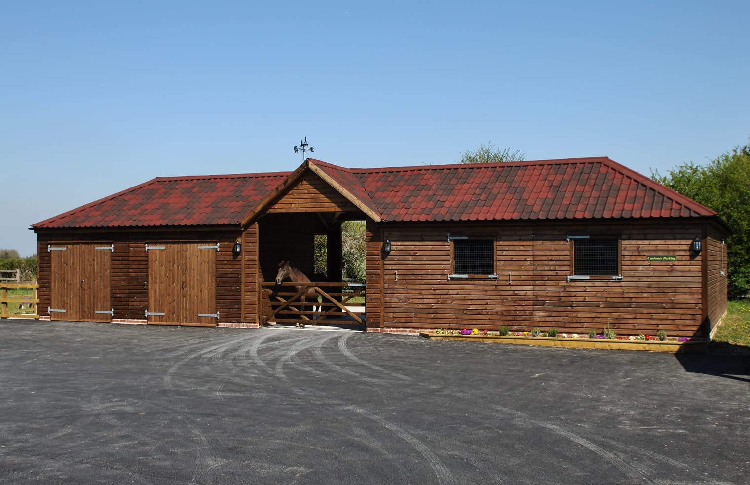 Timber stable block with a red tile-effect roof