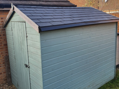 Light blue shed fitted with Onduline's BARDOLINE CLASSIC roof shingles in black
