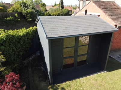 Onduline's Bardonline roof shingles on a grey shed with windows