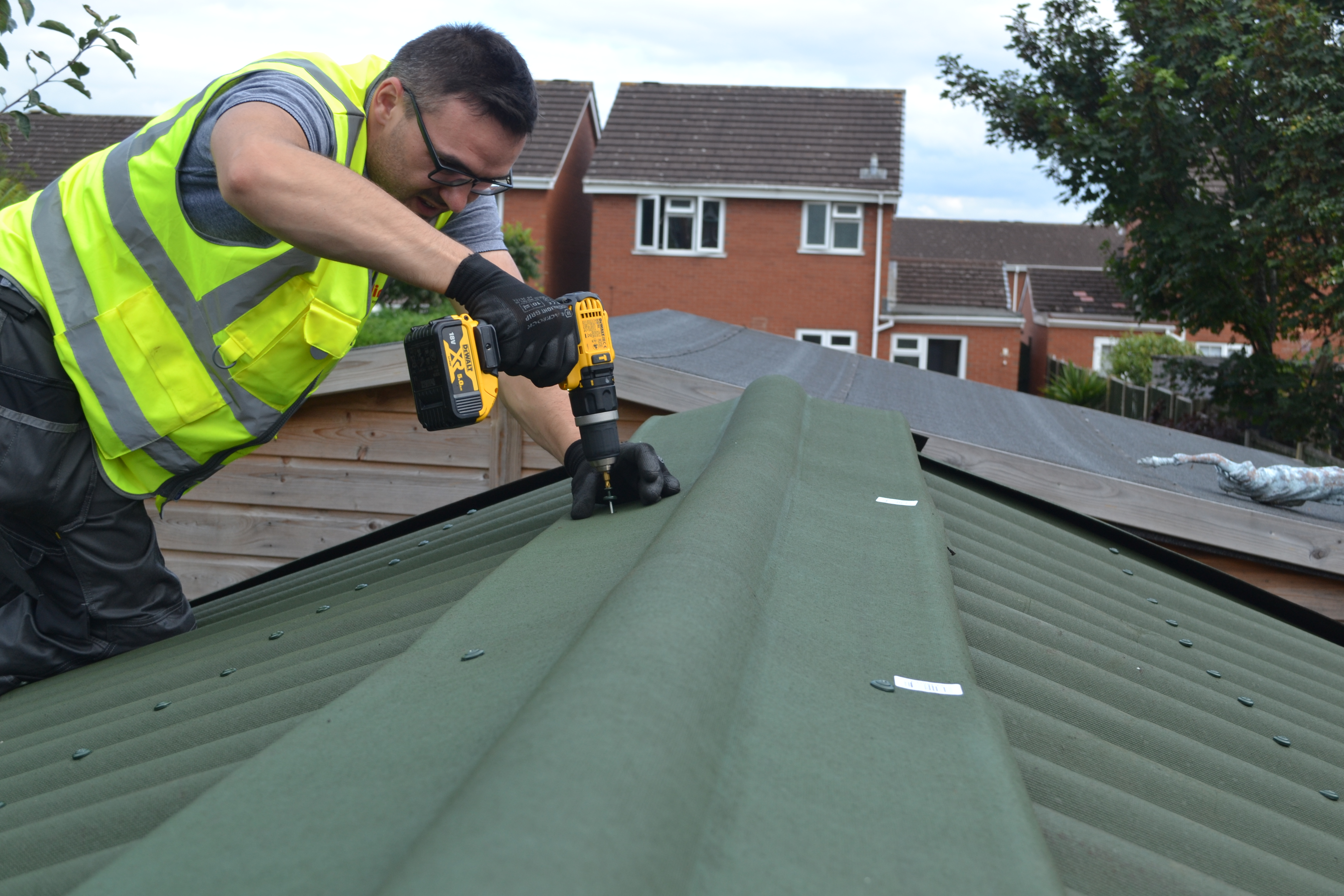 Man installing Onduline bitumen roofing sheets & verge