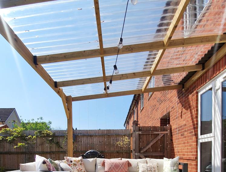 Outdoor seating area with pergola made from timber and Onduline clear roofing sheets