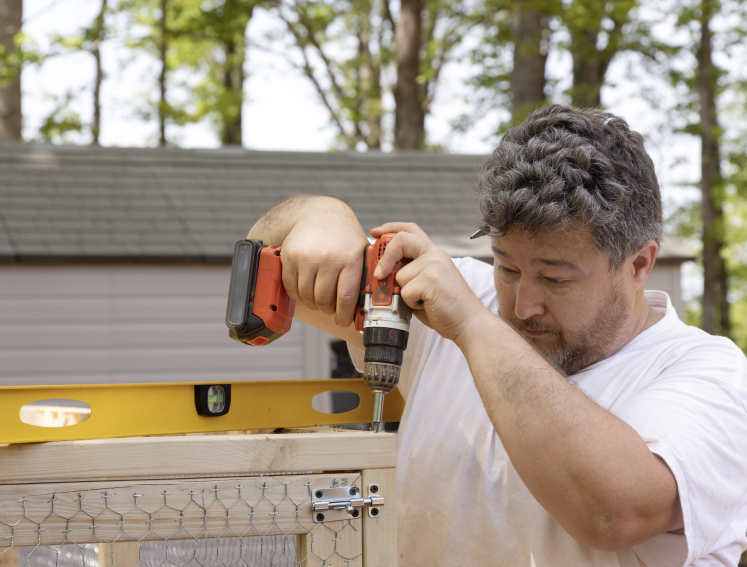 Man drilling in screws to timber frame 