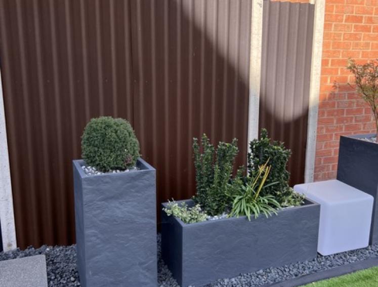 A garden fence reenforced with ONDULINE CLASSIC sheets
