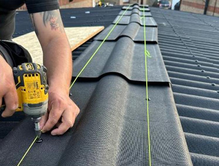 Man installing Onduline roofing ridges